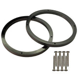 Two black HDPE speaker spacers with a bolt pattern and several screws placed next to them.