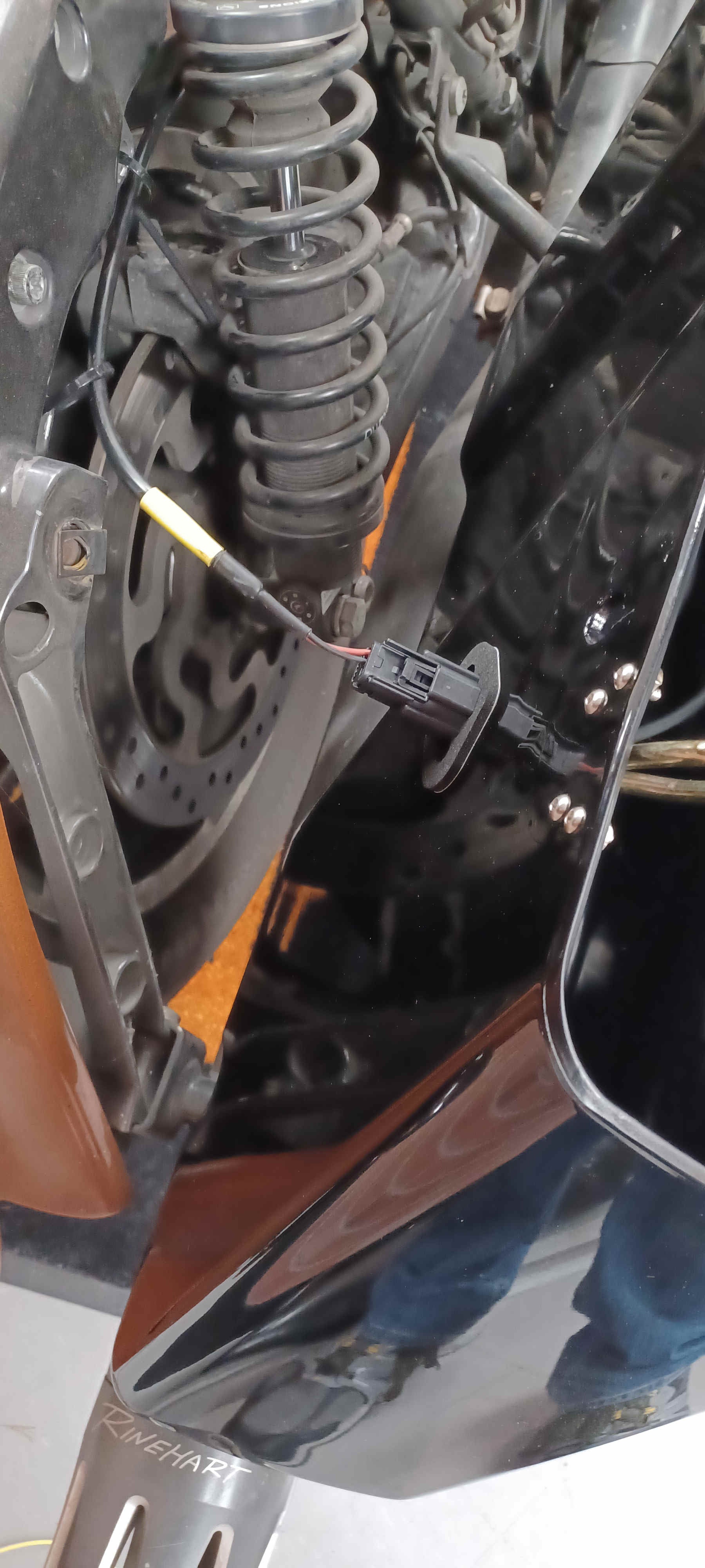 Backbone harness routed from the bag side and kept clear of moving parts